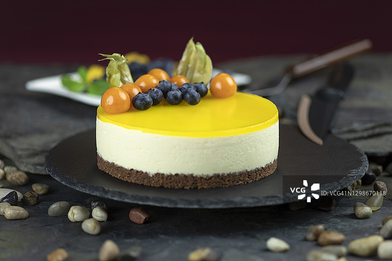 芒果芝士蛋糕与灯笼果、蓝莓装饰图片素材