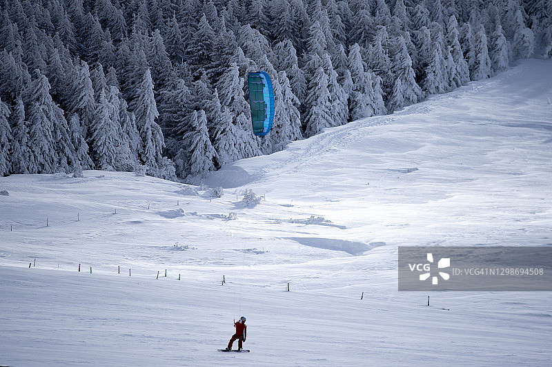 男人在雪地上玩雪地风筝图片素材