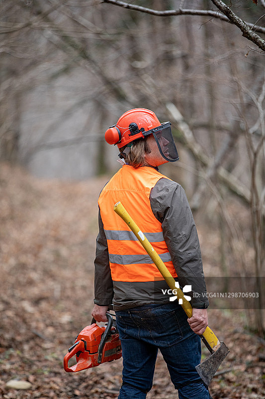 伐木工人在林地里手持斧头和油锯图片素材