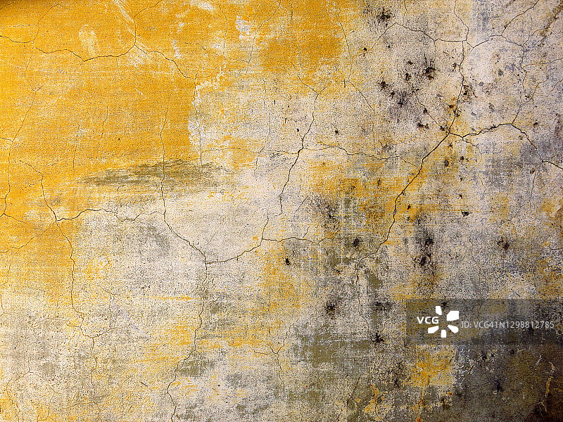 龟裂混凝土墙上的白色和黄色油漆图片素材