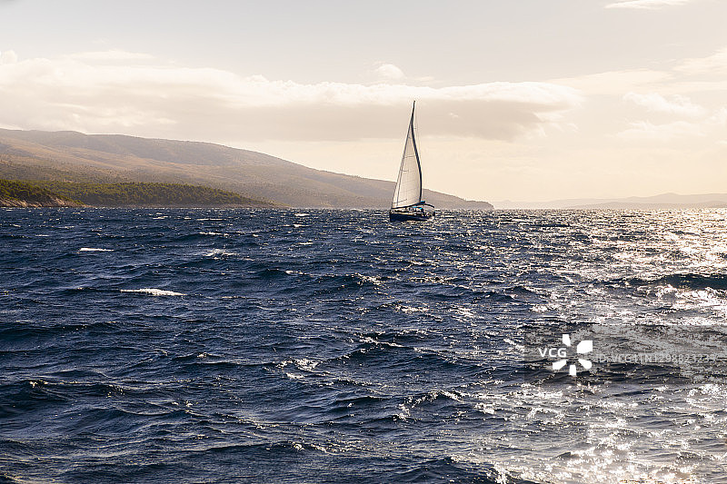 美丽云彩背景下，海上孤独的白色风帆游艇，夏季假期图片素材