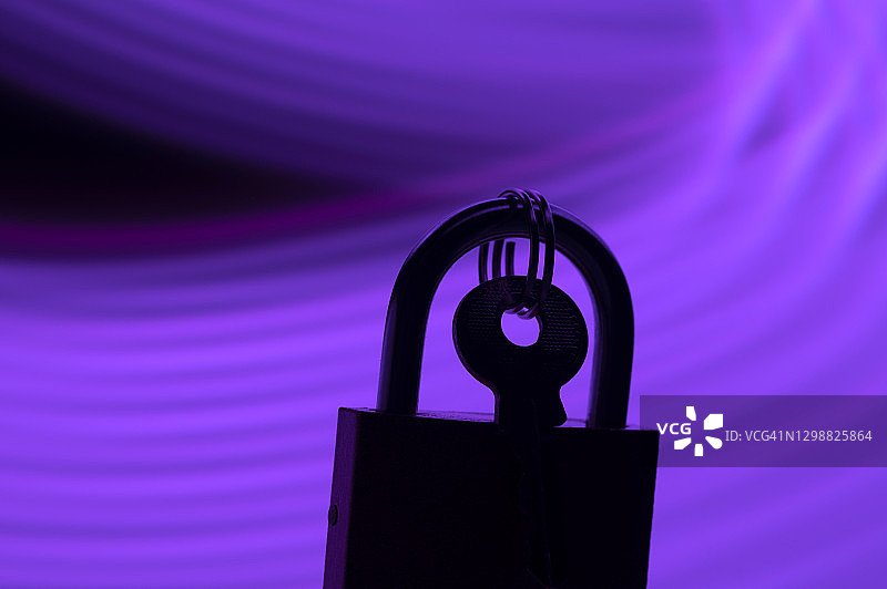 紫色线条神秘现代氛围中的带钥匙闭合挂锁图片素材
