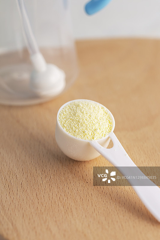 准备婴儿食品，勺子里的奶粉和奶瓶图片素材