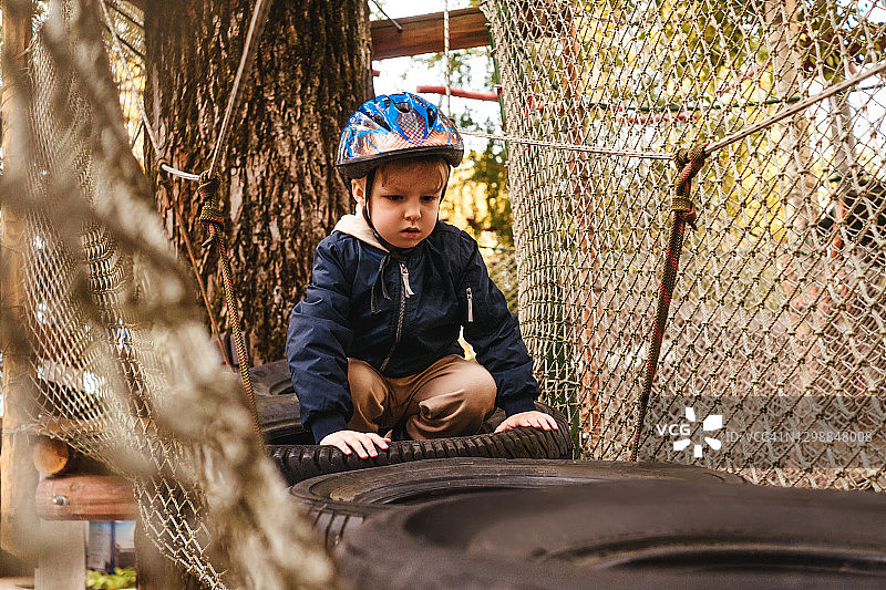 高空绳索攀爬冒险乐园 - 佩戴头盔和安全装备的孩子图片素材