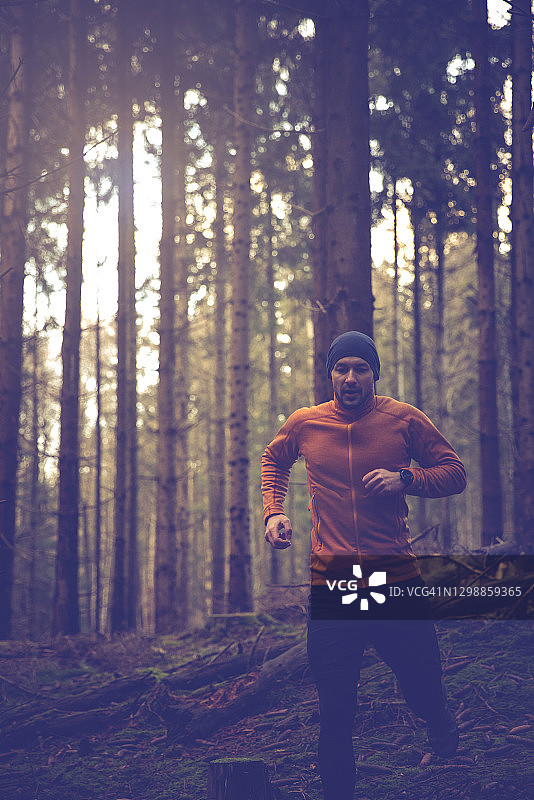 跑步者佩戴智能手表，身穿橙色外套图片素材