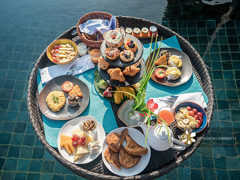 豪华酒店无边泳池上的漂浮早餐图片素材