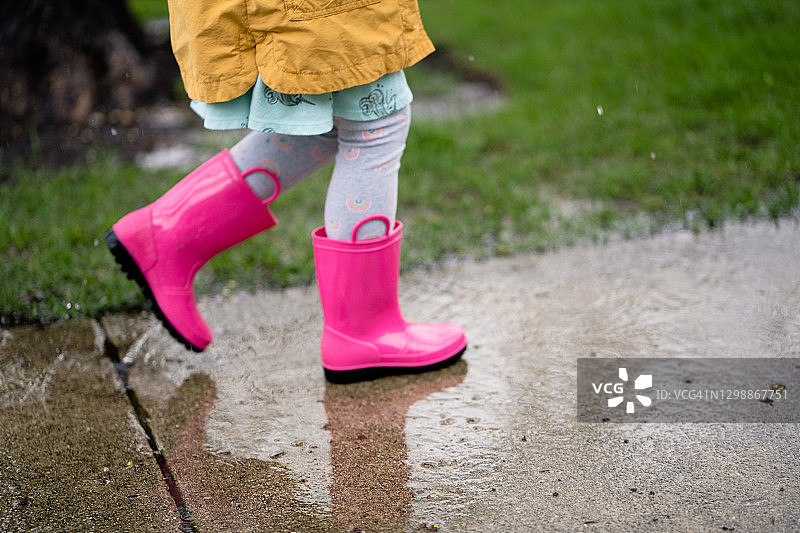 雨中彩虹下行走的女孩侧影图片素材