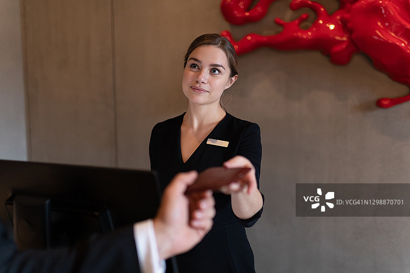 女接待员在商人离开酒店前收到房卡图片素材