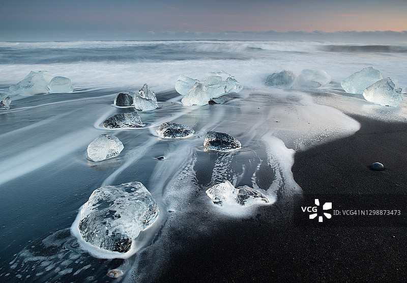 日出时海滩上的冰山图片素材