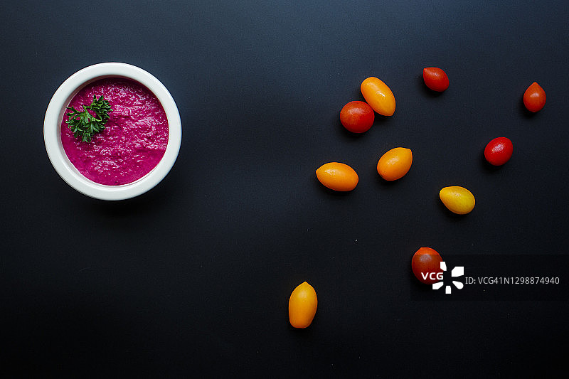 鲜艳的甜菜根鹰嘴豆泥和樱桃番茄的俯视图图片素材
