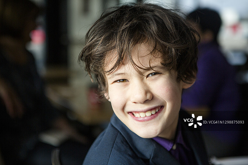 阳光下，西装革履的快乐男孩图片素材