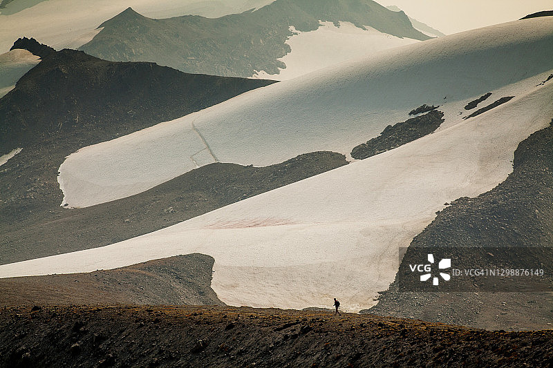 两位徒步旅行者下冰川峰，华盛顿的一座偏远火山图片素材