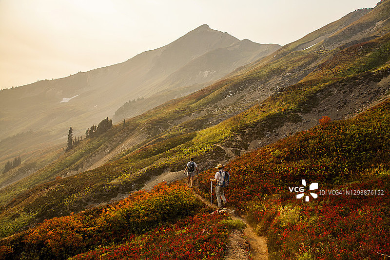 两位徒步旅行者下冰川峰，华盛顿的一座偏远火山图片素材
