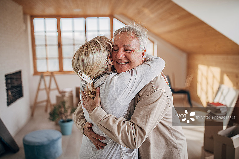 快乐的老年夫妇在新家里拥抱图片素材