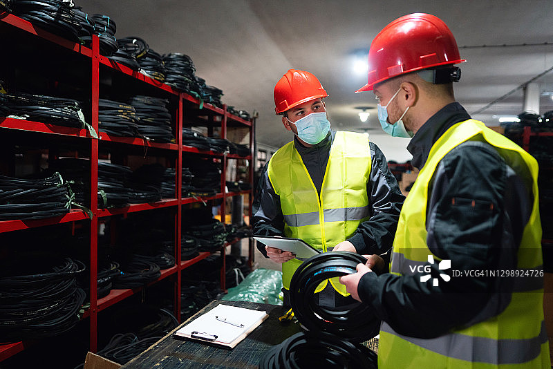 两名戴着防护面罩的工程师或工厂工人检查成品的质量图片素材