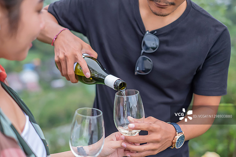 年轻的印度尼西亚夫妇在喝白葡萄酒图片素材
