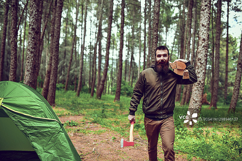 露营：男性伐木工人携带柴火准备篝火图片素材
