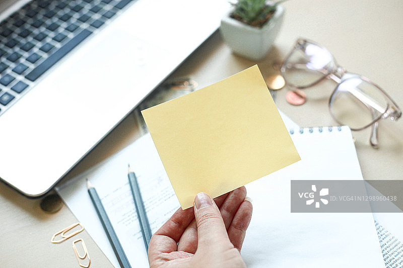 木桌上的记事本、铅笔、笔记本电脑、眼镜、钱和办公用品，税务时间或税务日概念图片素材