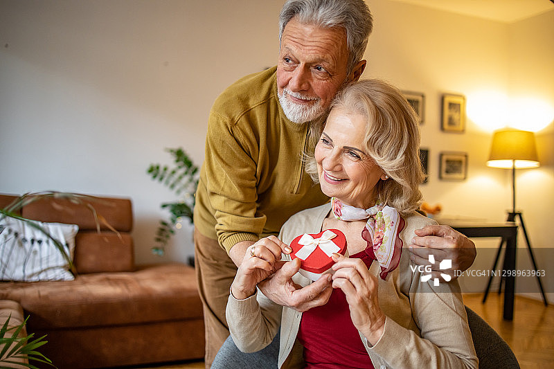 年长的男人给他的妻子送了一份爱的礼物图片素材