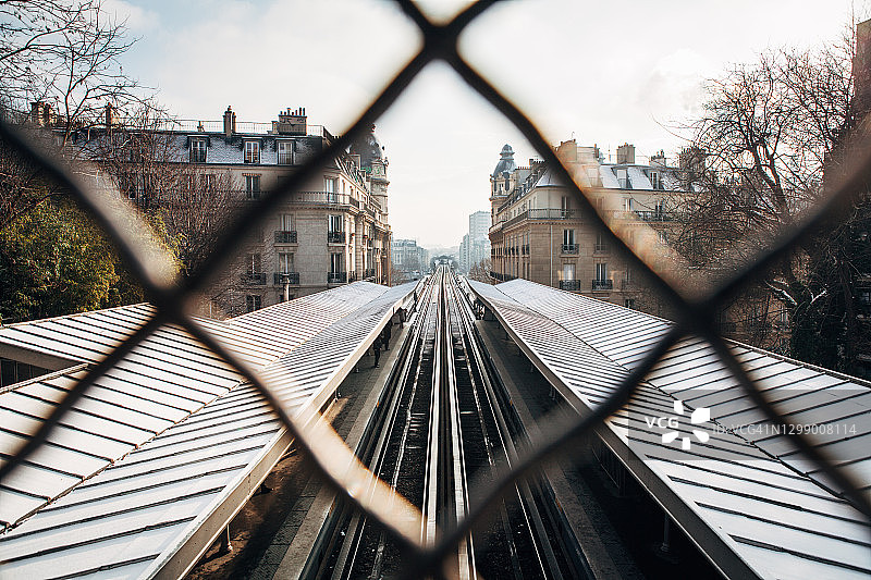 穿过金属栅栏的地铁轨道图片素材