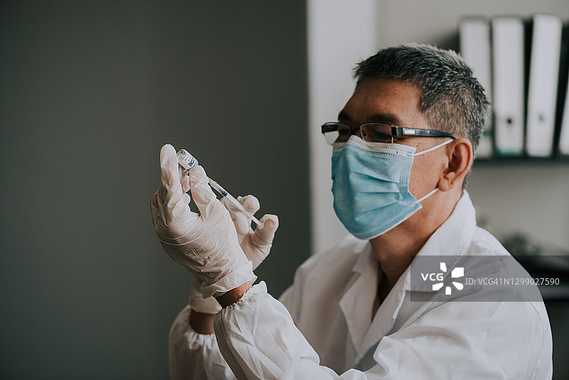 科学家手持新冠病毒疫苗玻璃瓶图片素材
