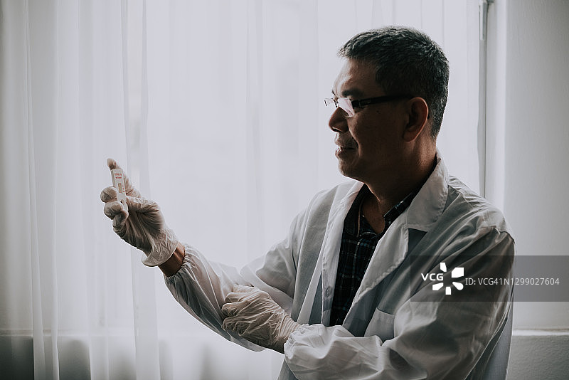 科学家手持新冠疫苗玻璃瓶图片素材