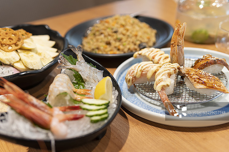 餐厅中的日式料理：刺身、寿司、沙拉、炒饭和海鲜汤图片素材