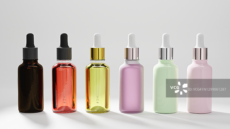 白色背景上带彩色油滴精油的玻璃瓶套装图片素材