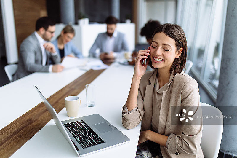 使用笔记本电脑和手机的商务女性图片素材