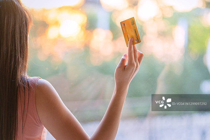 手持信用卡的年轻女顾客肖像图片素材