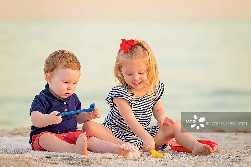 姐弟在沙滩上玩玩具图片素材