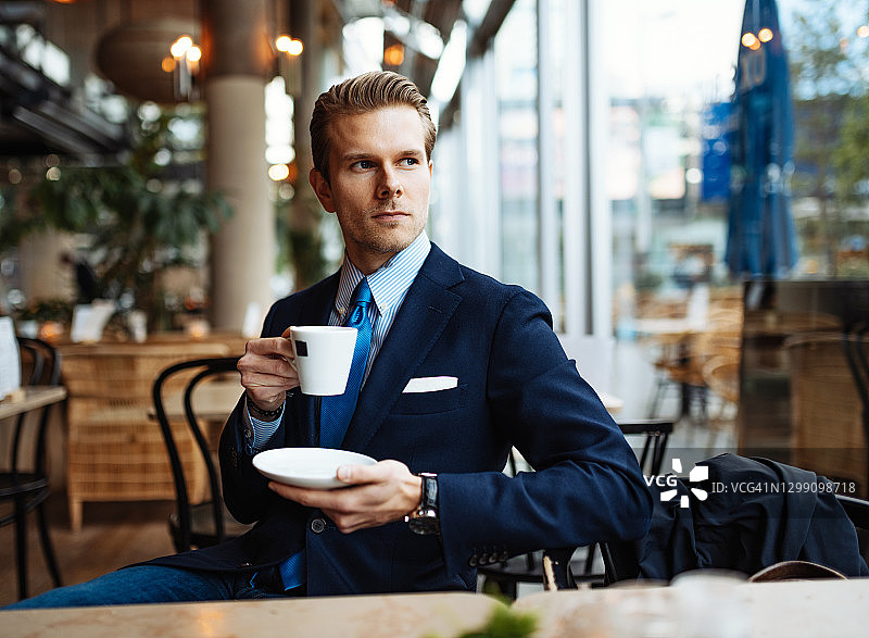 在咖啡馆身着正装，规划一天的商务人士图片素材