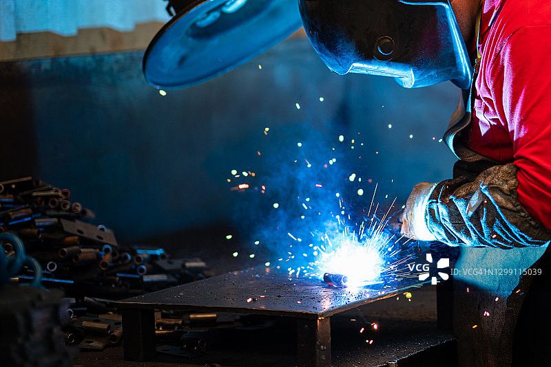 工厂工人身穿防护服进行焊接图片素材