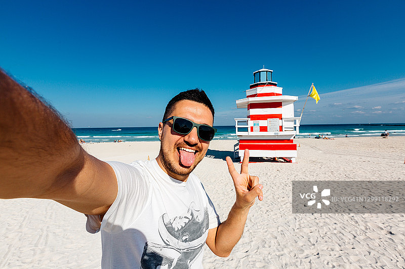 年轻男子在迈阿密南海滩戴着太阳镜自拍图片素材