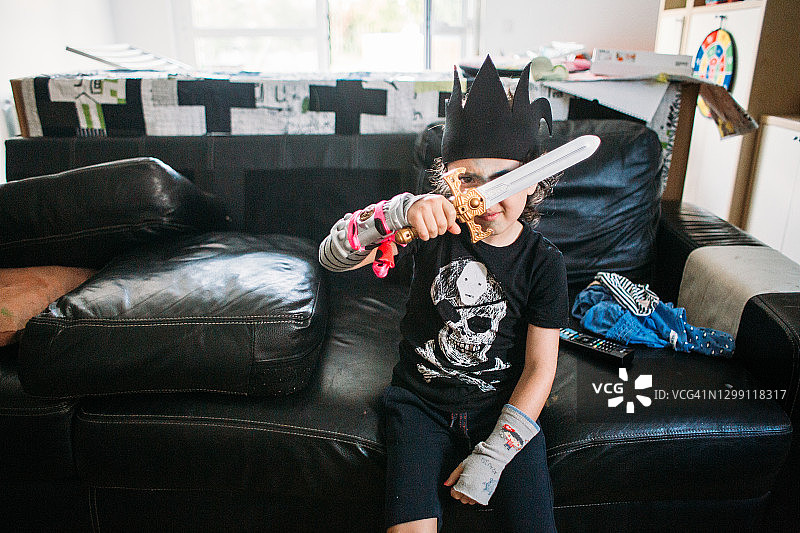 孩子在家装扮挥剑玩耍图片素材