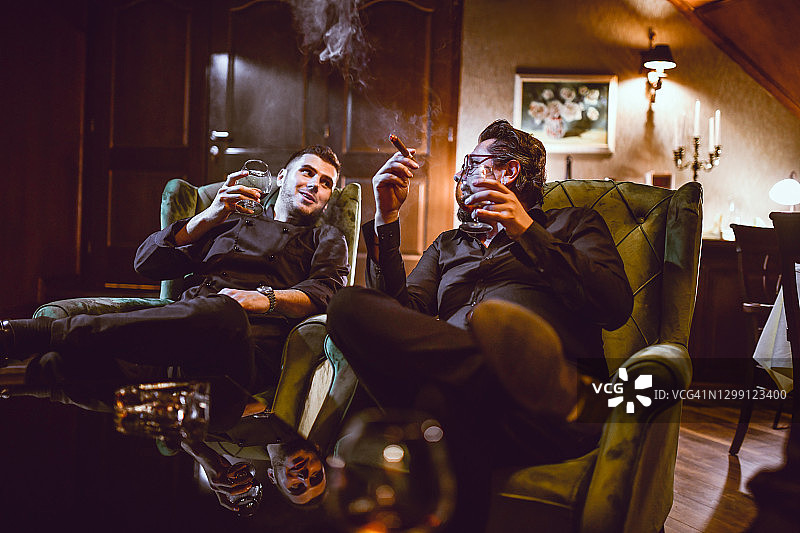 商人享用优质雪茄和干邑，畅谈工作与生活图片素材