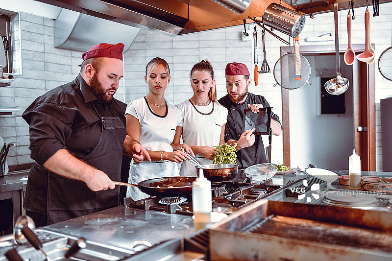 厨师参考平板电脑上的数字菜谱图片素材