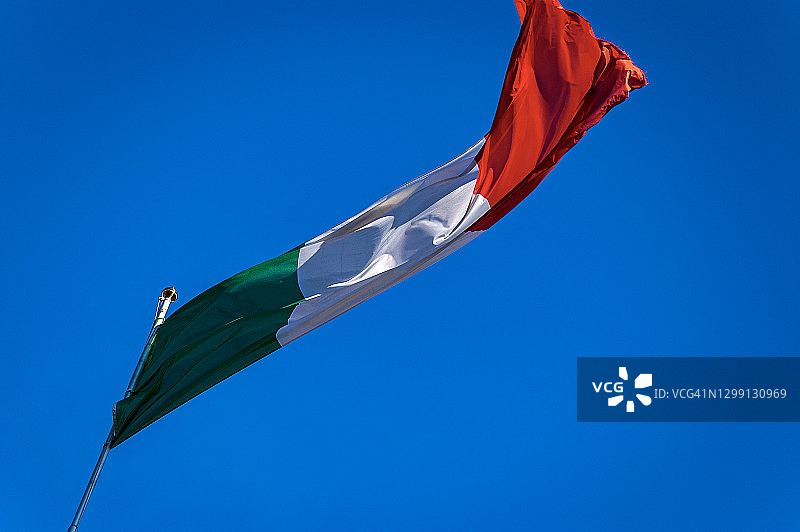 在蔚蓝天空下飘扬的意大利国旗图片素材