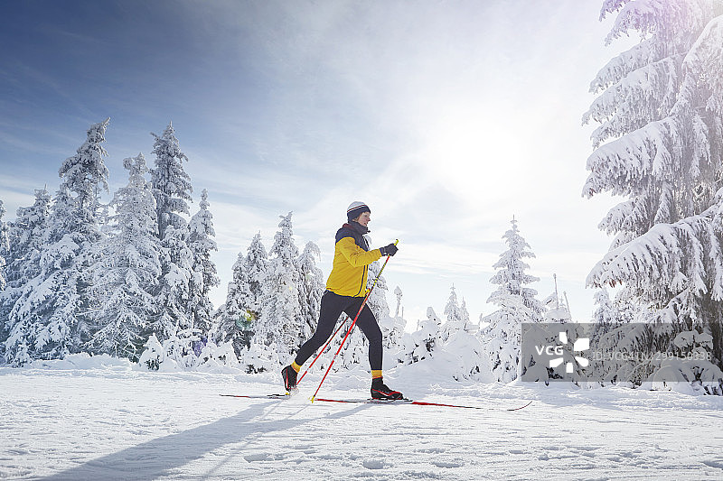 在阳光明媚的雪景中独自滑雪的女子图片素材