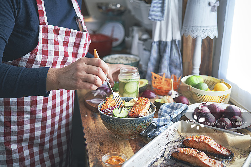 准备香辣三文鱼饭碗配米饭、胡萝卜、黄瓜和鳄梨图片素材