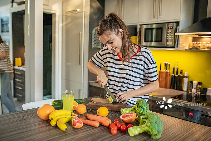 年轻女子在厨房准备健康膳食图片素材