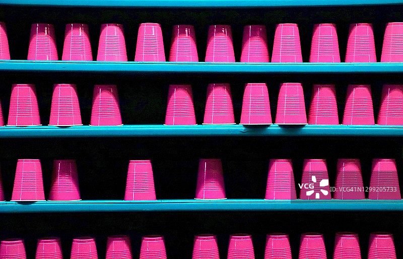 蓝色架子上的粉色塑料一次性杯子图片素材