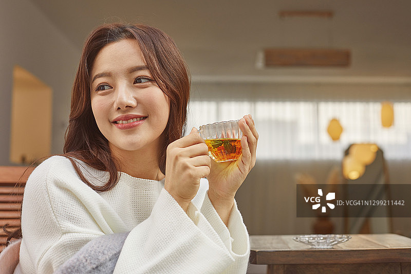 手捧茶杯的微笑女人图片素材