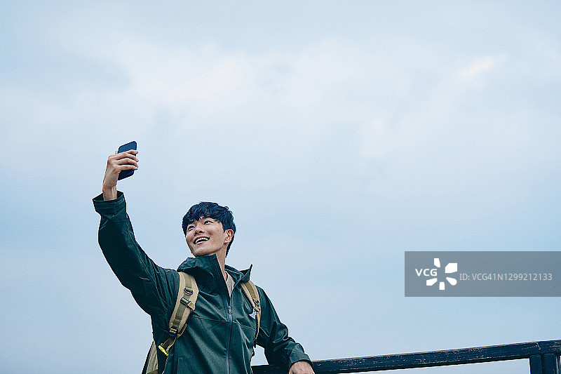 男子在山上用智能手机与人进行视频通话图片素材