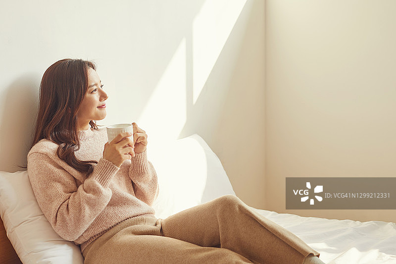 一名女子在房间里喝咖啡图片素材