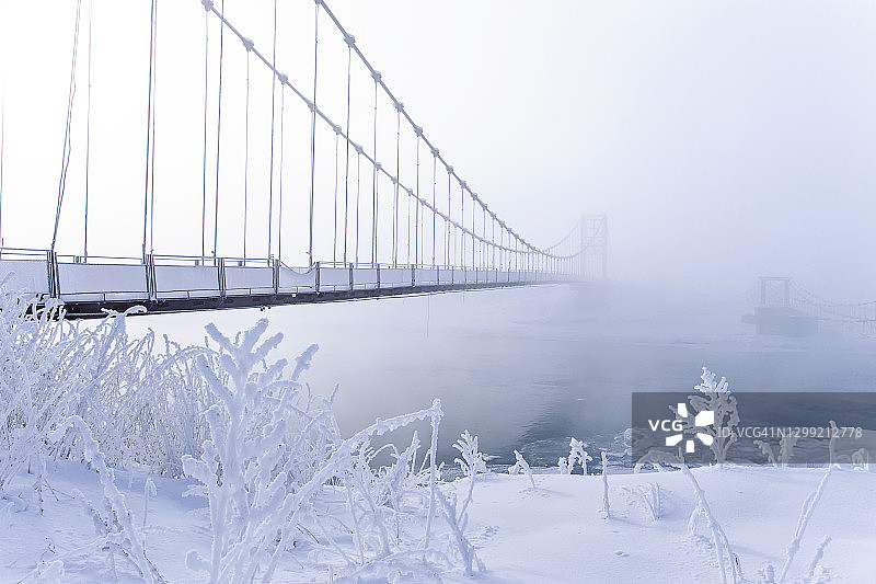 白色冬季霜冻景观与白雪皑皑的冰树和旧断桥，美丽的冰冻河流图片素材