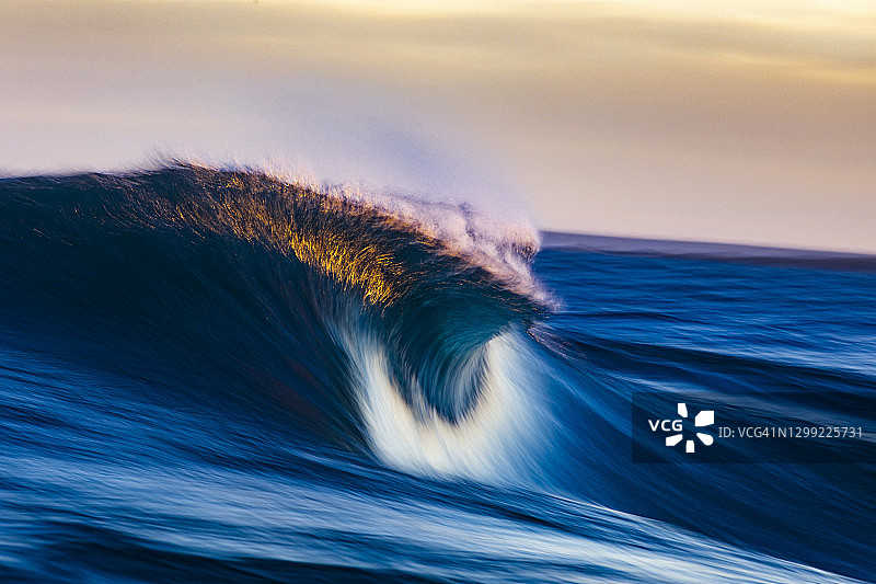 金色晨光中破碎的波浪图片素材