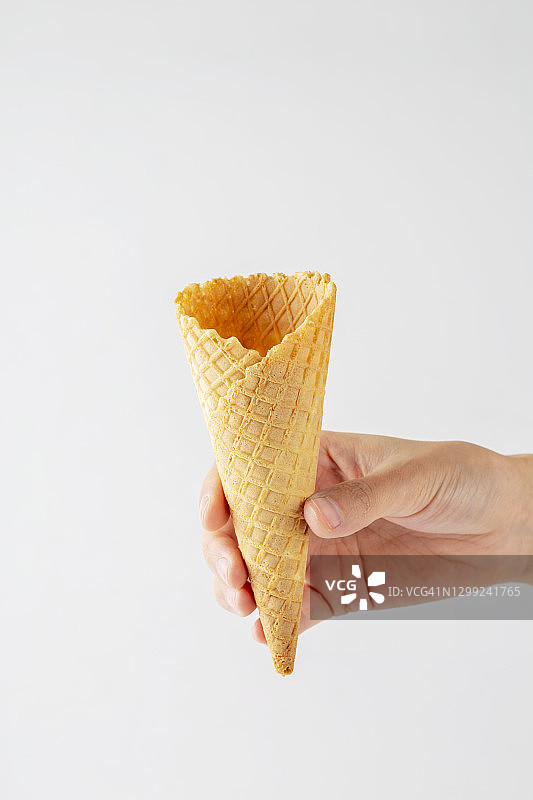 手持冰淇淋甜筒，白色背景图片素材