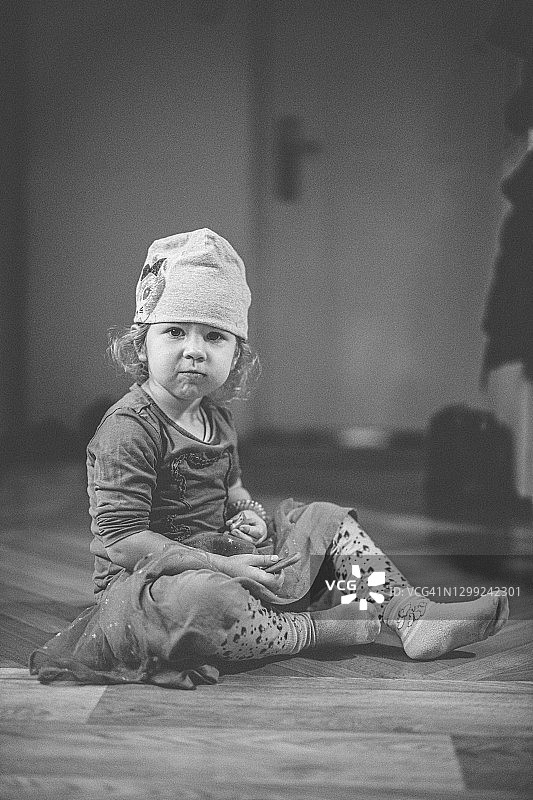 坐在地上吃东西的小女婴图片素材