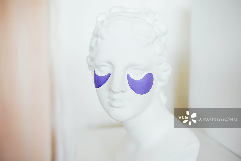 眼部贴化妆品的女性头部雕塑图片素材